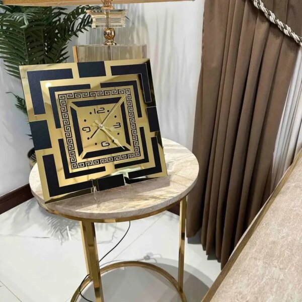 a black and golden color clock on the table