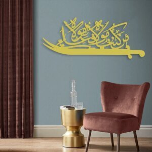 a golden color sword on the wall. Man Kunto Moula Calligraphy