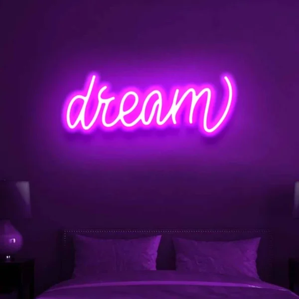 a neon light on the wall displays the text dream