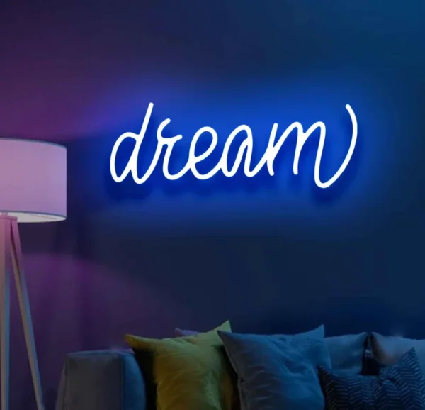 a neon light on the wall displays the text dream. Neon Light Dream Sign