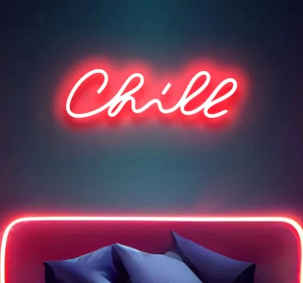 a neon light on the wall displays the text chill