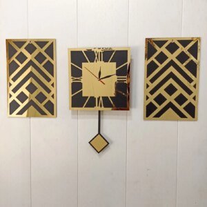 a black and golden color clock and two frames on the wall for wall decoration