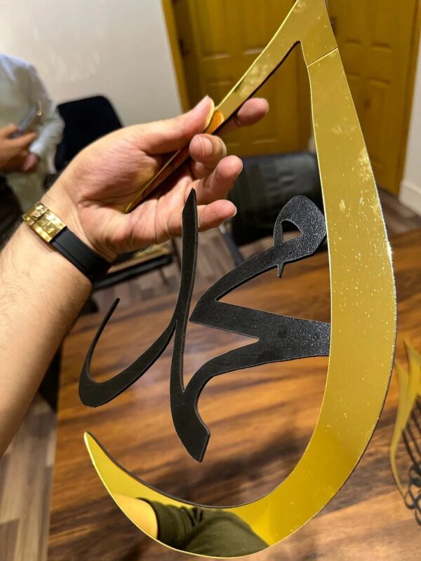 a hand holding golden color frame